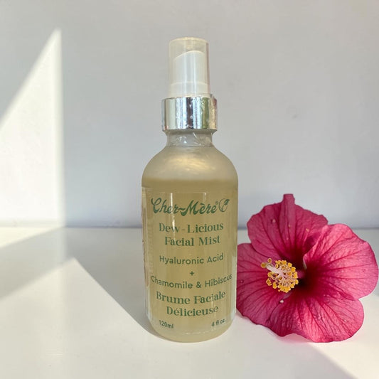 Facial mist bottle with pink flower on a white surface