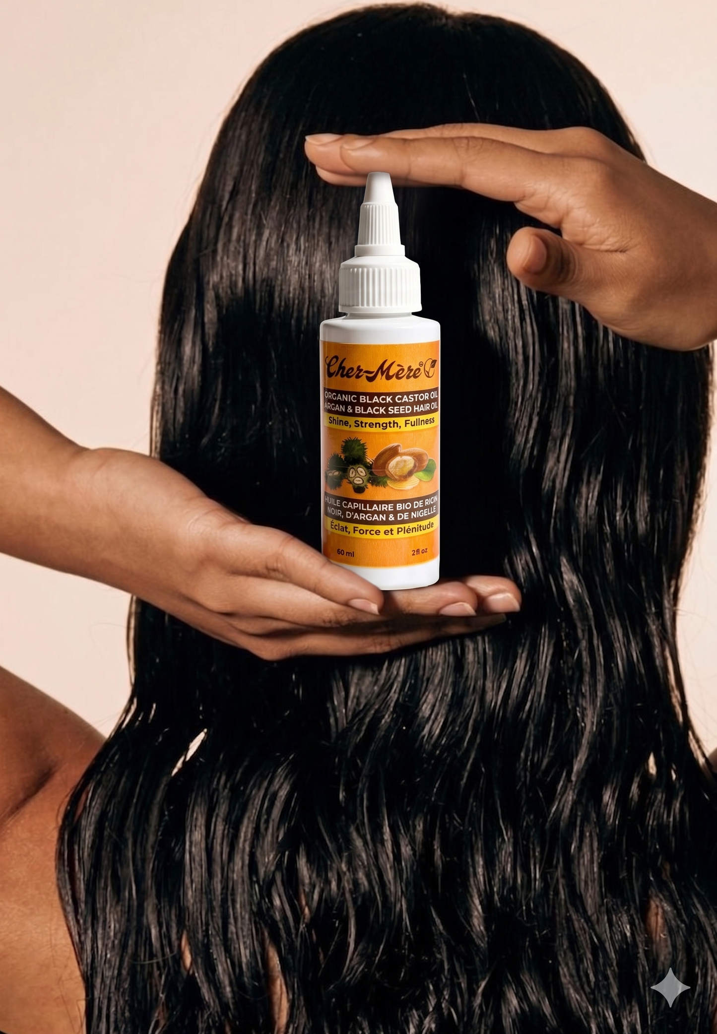 Person holding a bottle of hair care product with another hand on a beige background