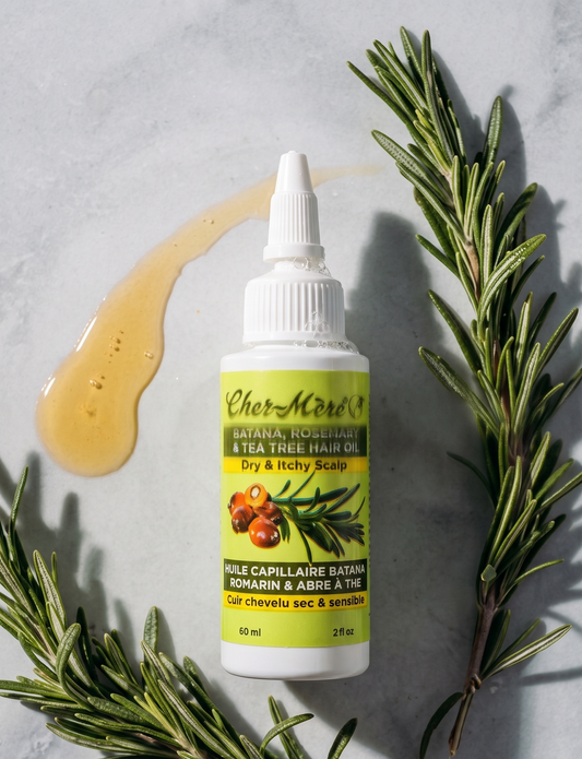 Bottle of CherMed herbal hair oil with rosemary leaves on a gray background