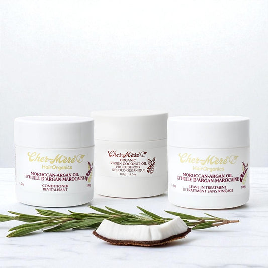 Three jars of 'Cher-Mere hair products on a white background with a coconut and rosemary.