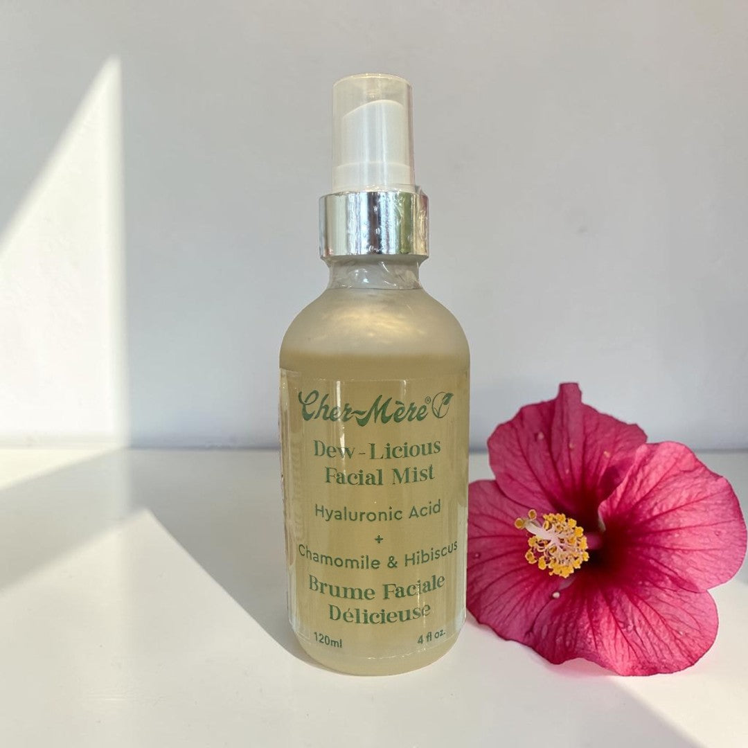 Facial mist bottle with pink flower on a white surface