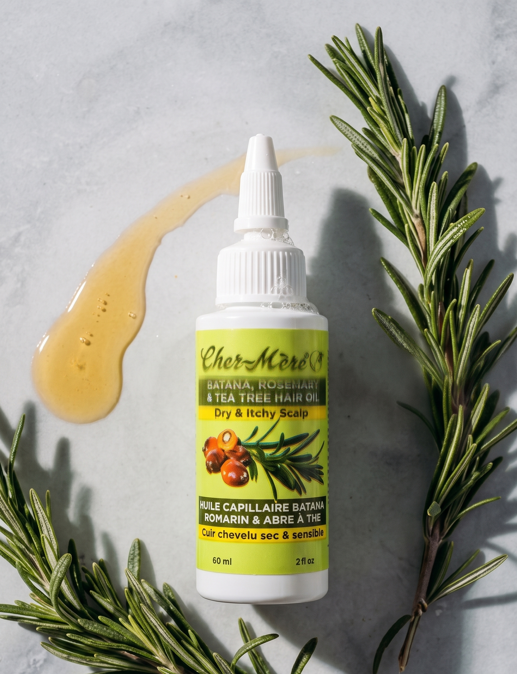 Bottle of CherMed herbal hair oil with rosemary leaves on a gray background