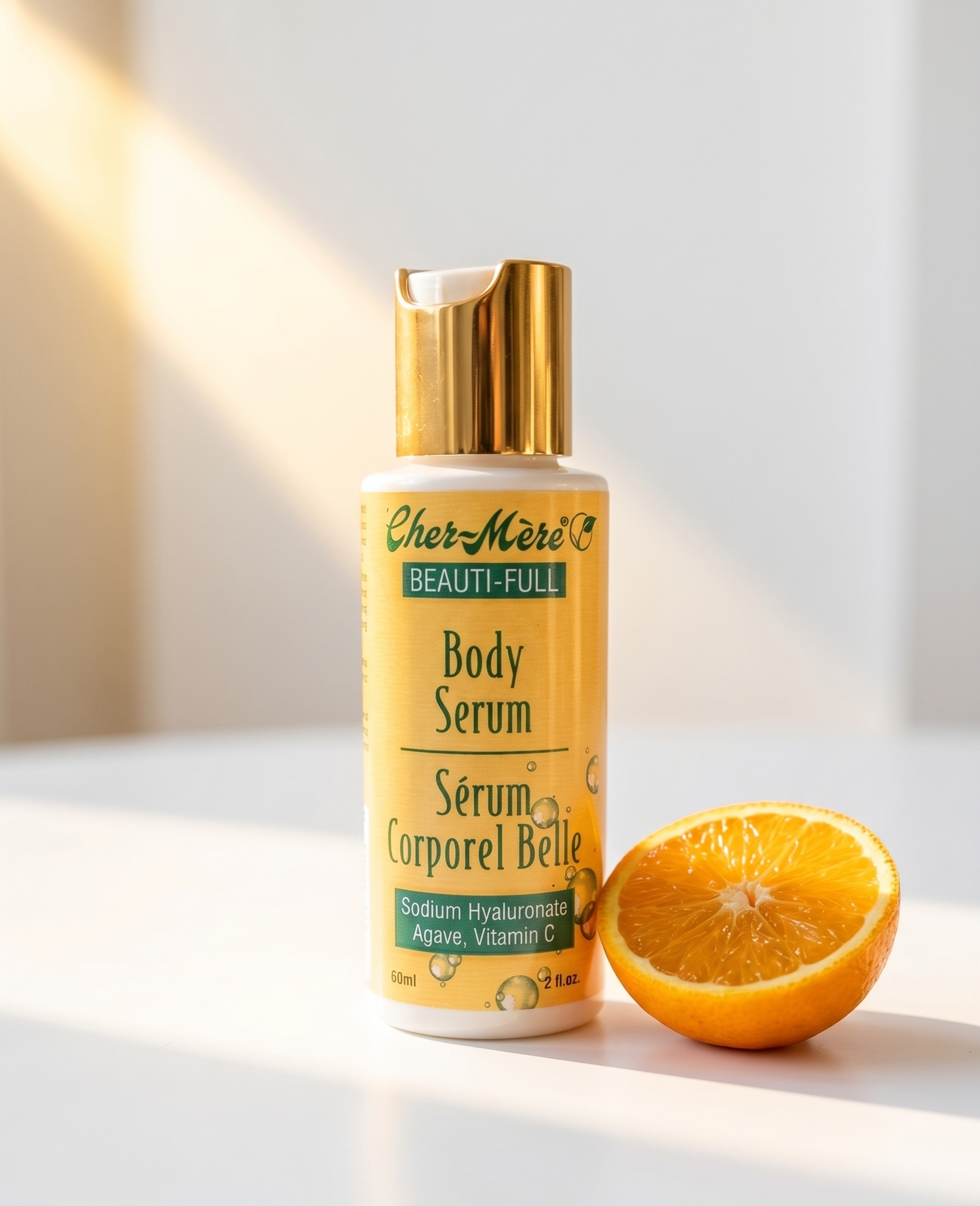 Body serum bottle with a gold cap and half an orange on a light background