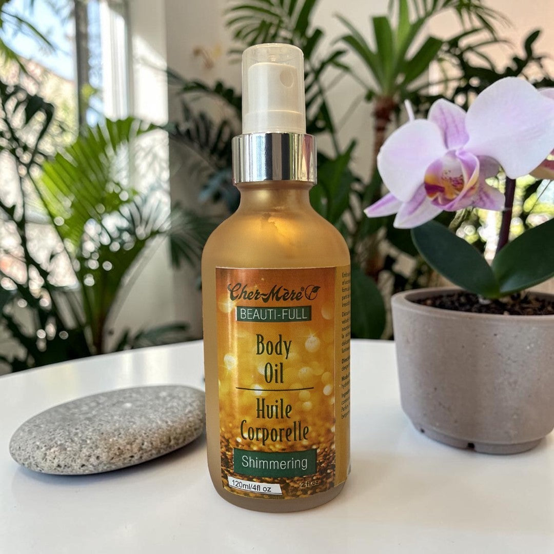 Bottle of Cher Meri Body Oil on a table with plants in the background